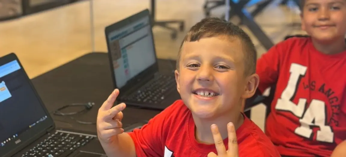 Des enfants apprennent à coder avec un formateur Codaquest